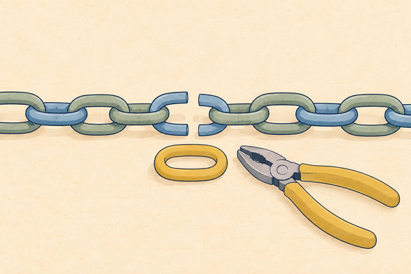 A chain with one broken link, a new mustard link and pliers beside it